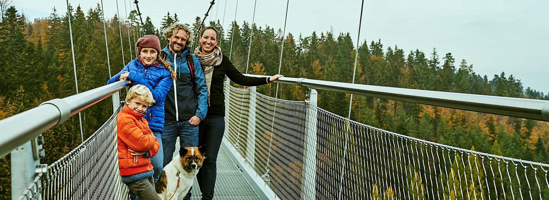 Visiteur avec chien sur le pont suspendu WILDLINE
