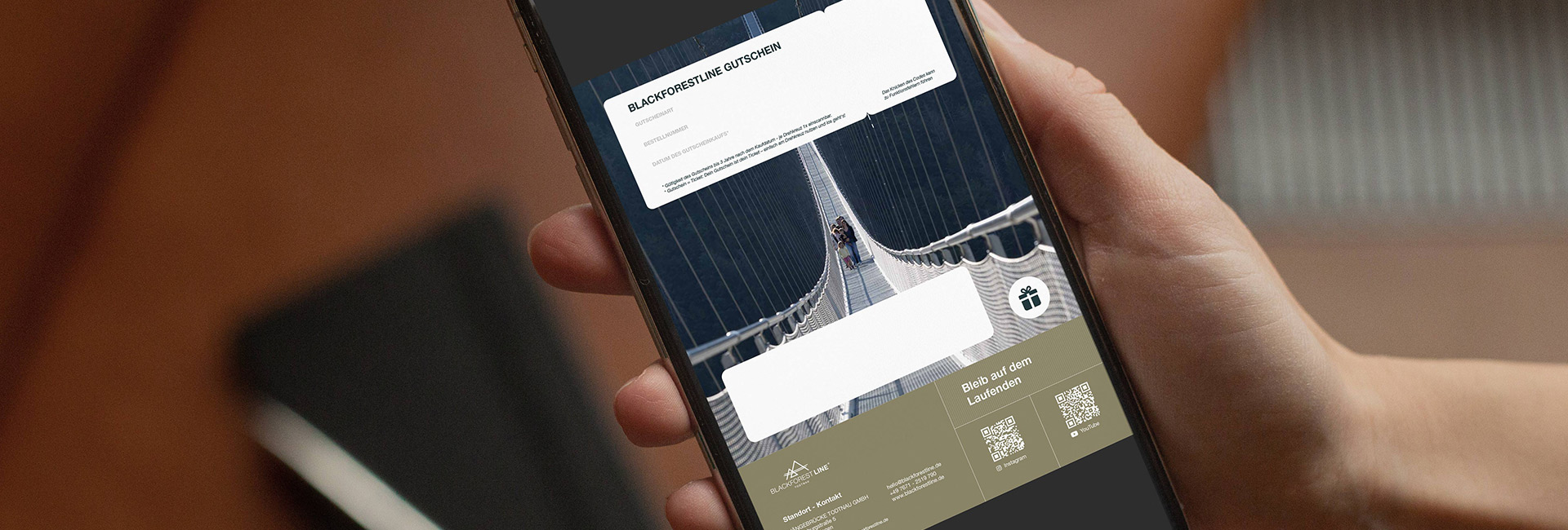 Handy auf dem ein Gutschein für die BLACKFORESTLINE zu sehen ist
