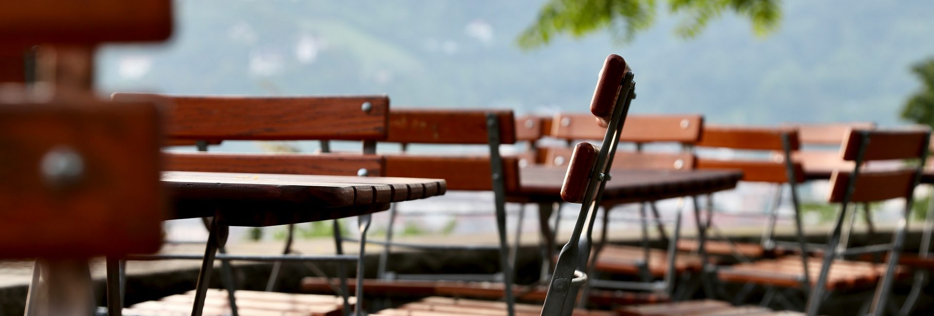 Restaurant-Terrasse mit Gartenstühlen und Bänken